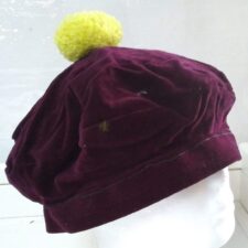 Purple cap with yellow pom pom
