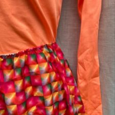 Bright orange catsuit with pink print skirt