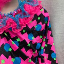 Hot pink, black and turquoise skirted bike shorts, crop top, hat and boot covers